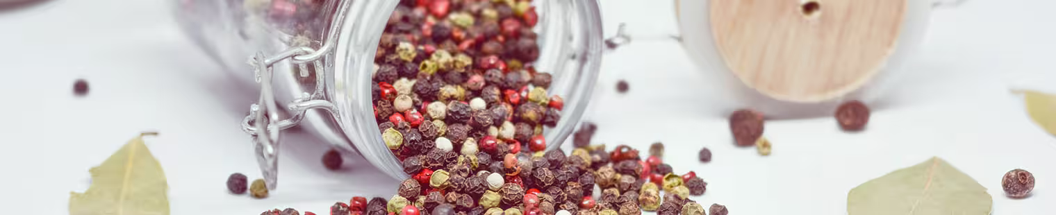 The banner of the Amazing Allspice website - a jar of allspice seeds from the tree.